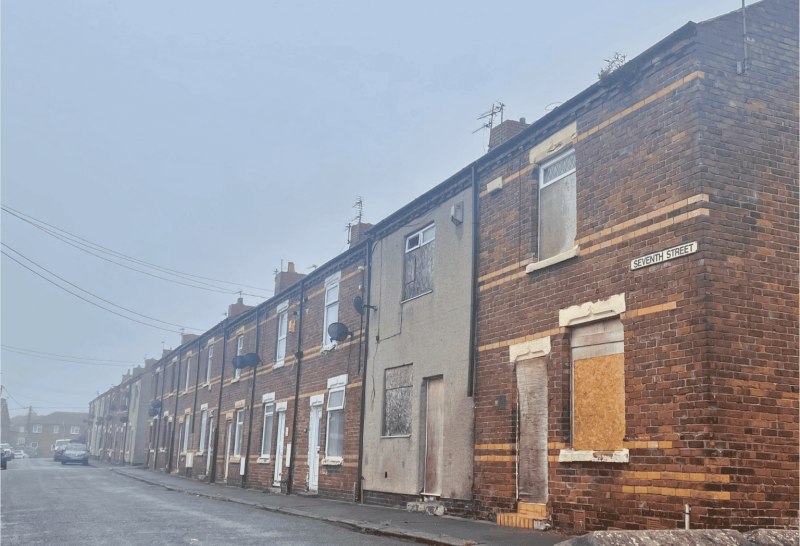 A street of boarded up terraced houses 