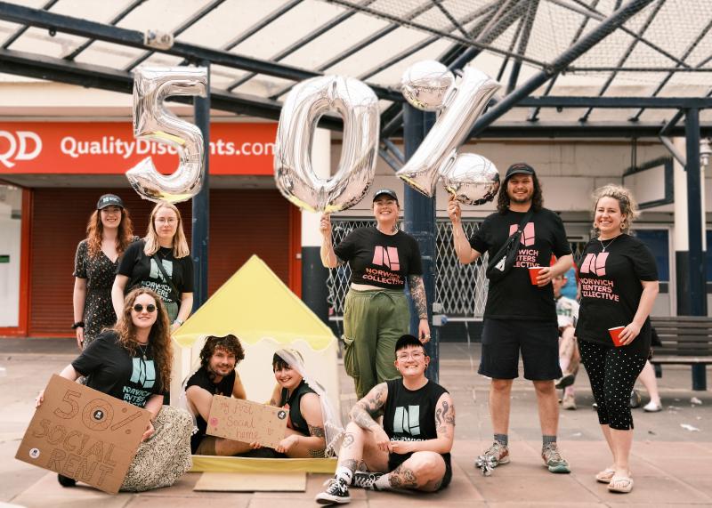 Group of members of the Norwich renters collective hold '50%' balloons looking jubilant