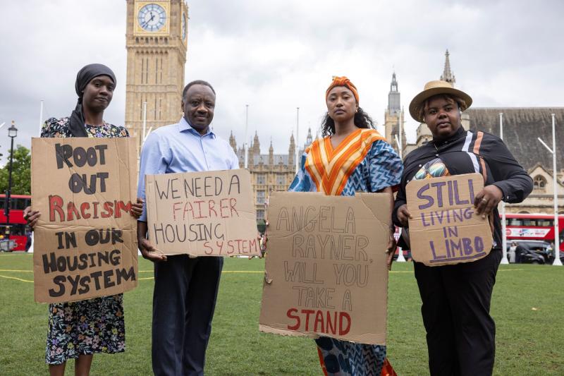 Peer researchers at Shelter who helped with the research and co-production for this campaign posing with signs advocating against systemic racism in housing.